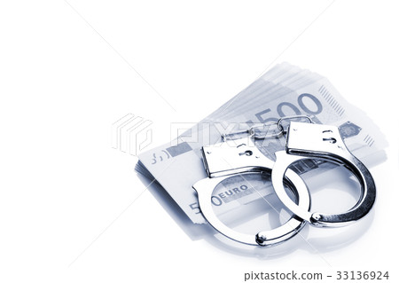 Pair of handcuffs closeup on euro banknotes stack 33136924