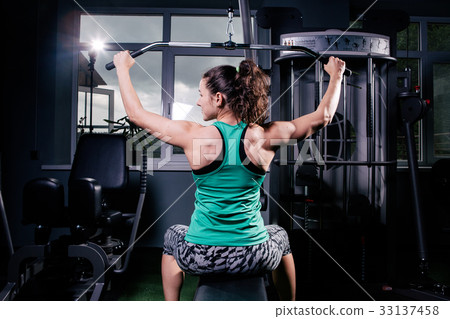 Young woman with ponytail at the gym using fitness equipment. Young woman with ponytail at the gym using fitness equipment. 33137458