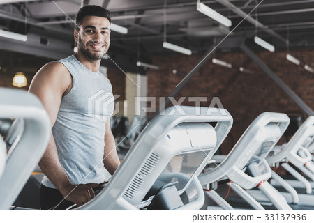 Cheerful bearded man making exercise in gym Cheerful bearded man making exercise in gym 33137936