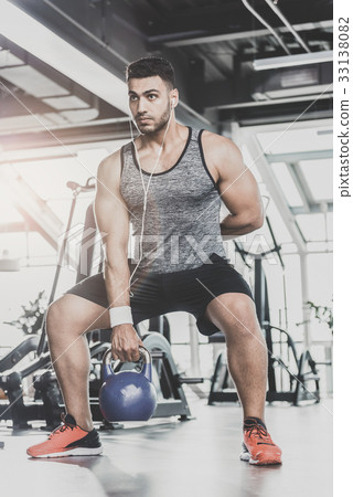 Serene male practicing with equipment in gym Serene male practicing with equipment in gym 33138082
