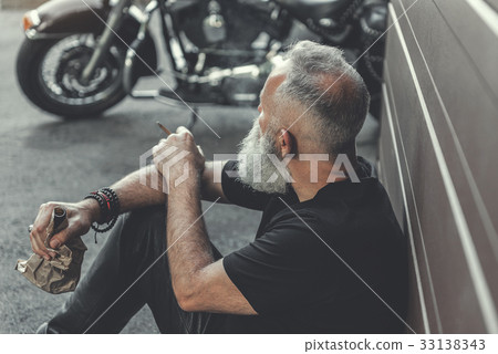 Relaxed aged male person keeping cigar Relaxed aged male person keeping cigar 33138343