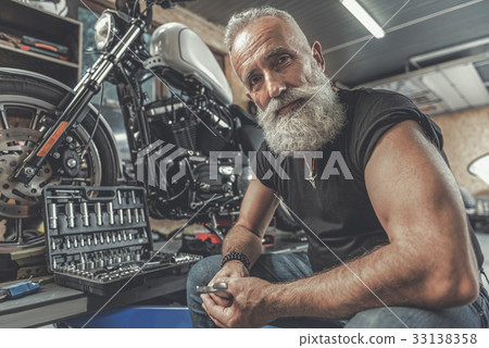 Cheerful old man ready for motorbike renovation 33138358