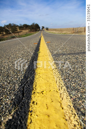 Asphalt road that goes straight under the blue sky 33139041