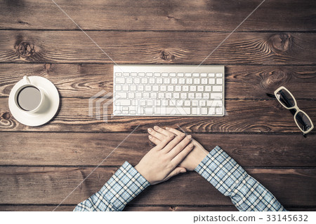 Top view of woman sitting at table with hands folded Top view of woman sitting at table with hands folded 33145632