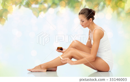 beautiful woman applying depilatory wax to her leg 33146003