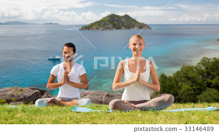 happy couple doing yoga and meditating outdoors 33146489