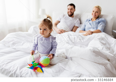 happy child with toys and parents in bed at home 33146884