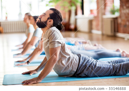 group of people doing yoga cobra pose at studio 33146888