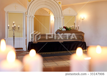 burning candles and coffin in church at funeral 33147906