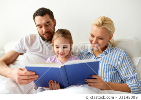 happy family reading book in bed at home 33148099