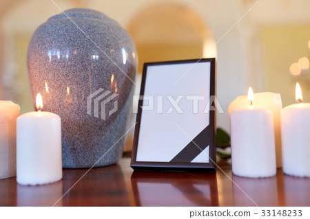 photo frame, cremation urn and candles in church 33148233