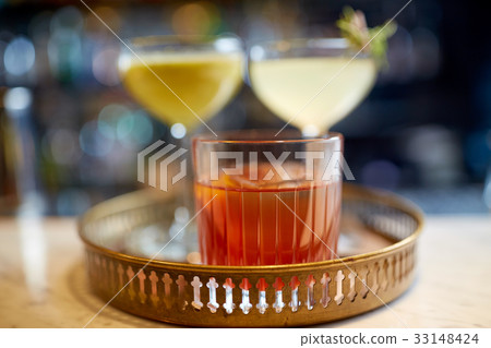 tray with glasses of cocktails at bar 33148424