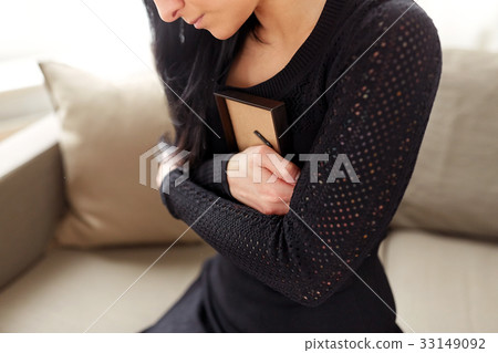 woman with photo frame at funeral day 33149092