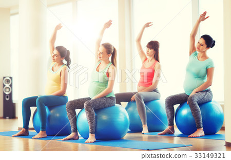 happy pregnant women exercising on fitball in gym 33149321