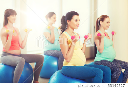 happy pregnant women exercising on fitball in gym 33149327
