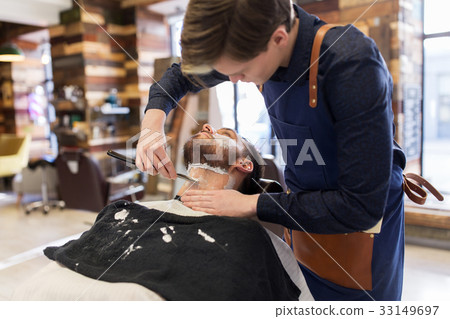 barber with straight razor shaving clients beard 33149697