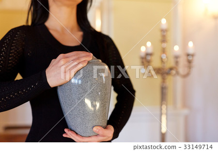 close up of woman with cremation urn in church 33149714