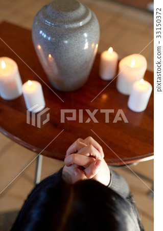 sad woman with funerary urn praying at church sad woman with funerary urn praying at church 33150372