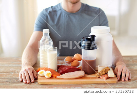 close up of man with food rich in protein on table 33150738