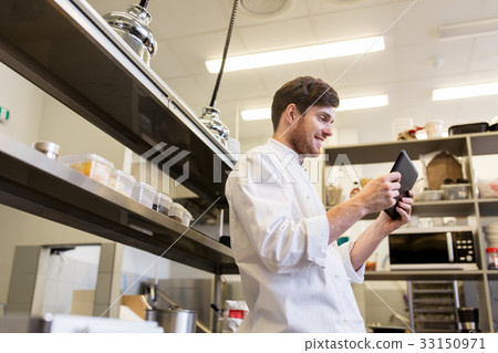 圖庫照片: chef cook with tablet pc at restaurant kitchen