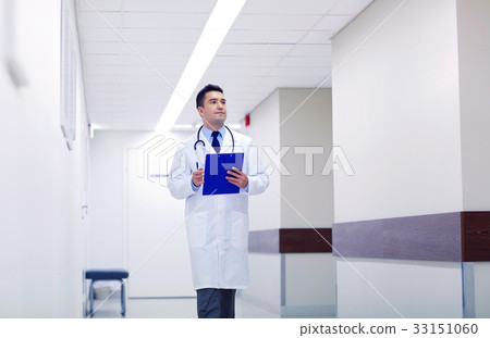doctor with clipboard walking along hospital 33151060
