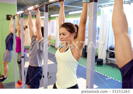 group of people hanging at horizontal bar in gym 33151263