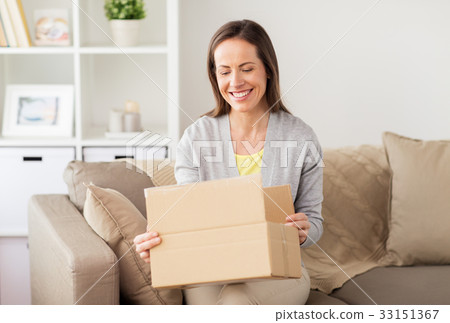 smiling woman opening cardboard box 33151367