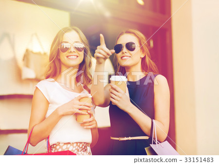 young women with shopping bags and coffee at shop young women with shopping bags and coffee at shop 33151483