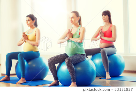 happy pregnant women exercising on fitball in gym 33151837