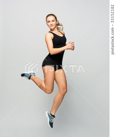 young woman in black sportswear jumping young woman in black sportswear jumping 33152182