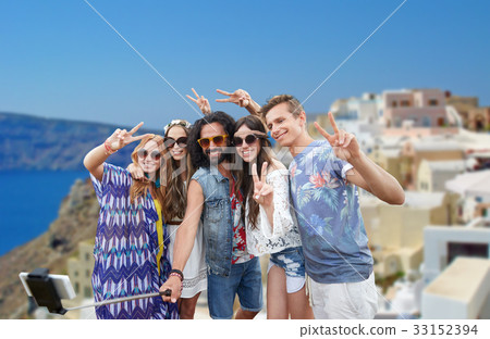 hippie friends with smartphone on selfie stick 33152394