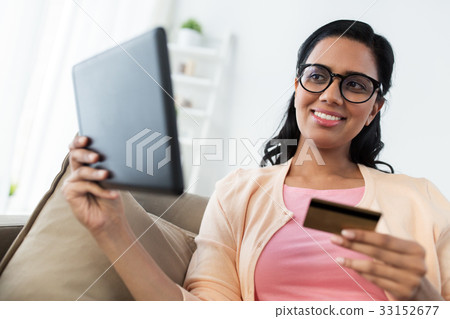 happy woman with tablet pc and credit card at home 33152677