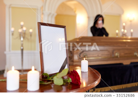 photo frame and woman crying at coffin at funeral 33152686