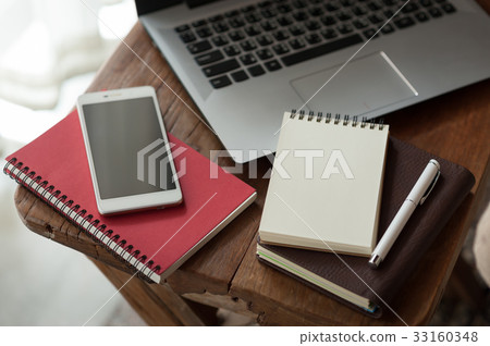 Notebook and laptop computer on wood table 33160348