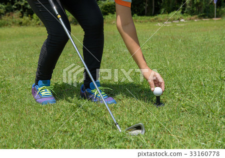 Asian golfer put golf on tee in green golf course Asian golfer put golf on tee in green golf course 33160778
