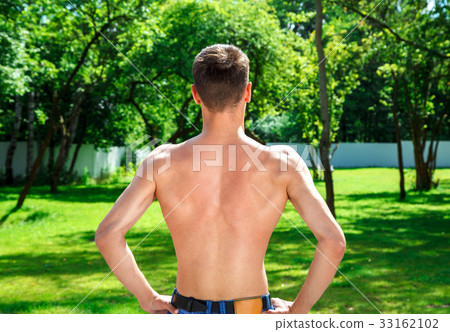 young male athlete demonstrates his back muscles 33162102