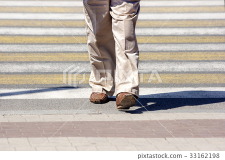elderly woman crossing a street in the city 33162198