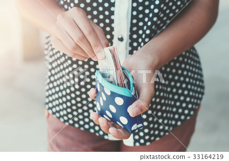 Hands holding bank bills and small money pouch 33164219