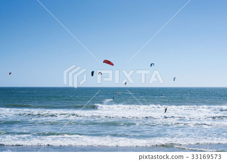 Remote view at kite surfers riding the waves Remote view at kite surfers riding the waves 33169573