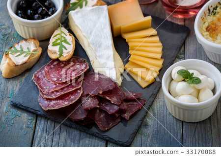 Sliced meat and cheese on the board 33170088
