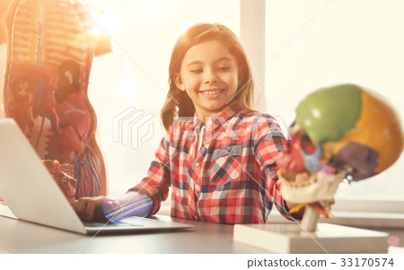 Joyful kid playing with model of head 33170574