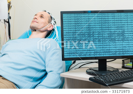 Brain waves of young man being displayed on screen 33171973