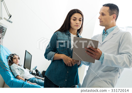 Doctor asking mother of little patient to sign 33172014