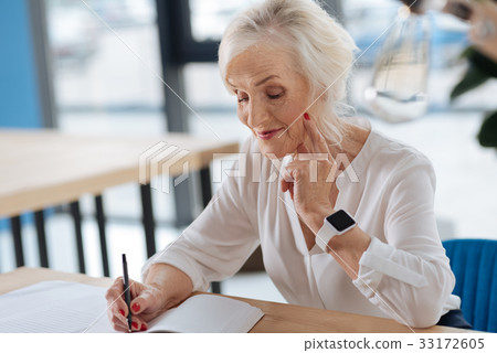 Happy aged woman writing down her memories 33172605