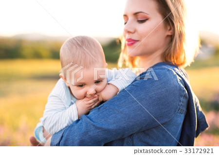 Young mother in nature with baby son in the arms. Young mother in nature with baby son in the arms. 33172921