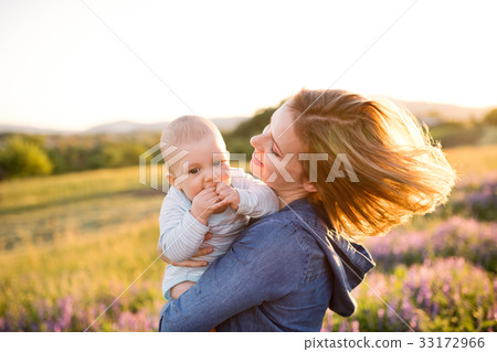 Young mother in nature with baby son in the arms. 33172966