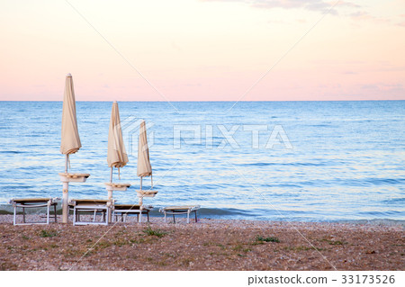 closed umbrellas on evening beach closed umbrellas on evening beach 33173526