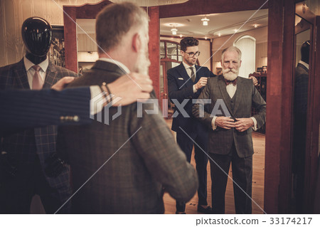 Tailor and client measuring custom made garment Tailor and client measuring custom made garment 33174217