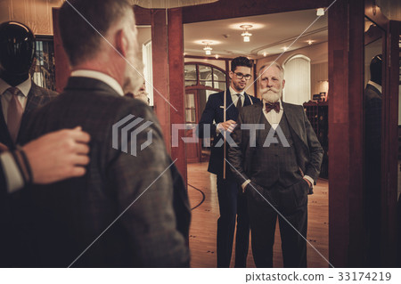 Tailor and client measuring custom made garment 33174219