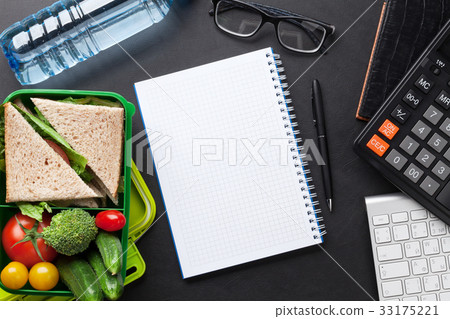 Office desk with supplies and lunch box 33175221